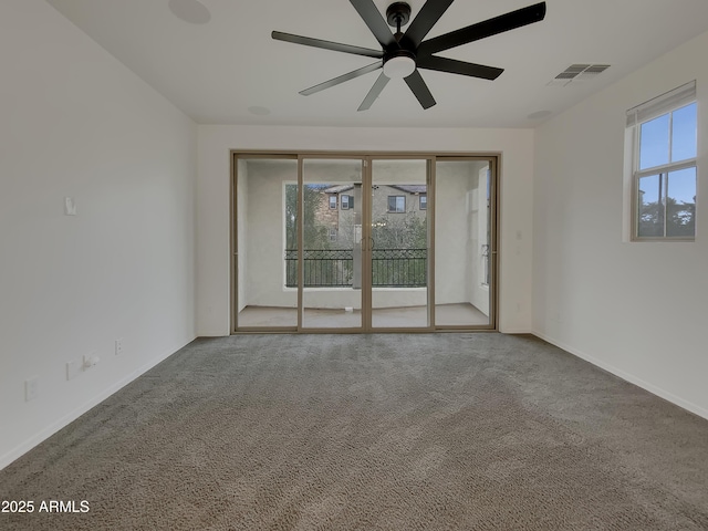 spare room featuring visible vents, carpet floors, and plenty of natural light