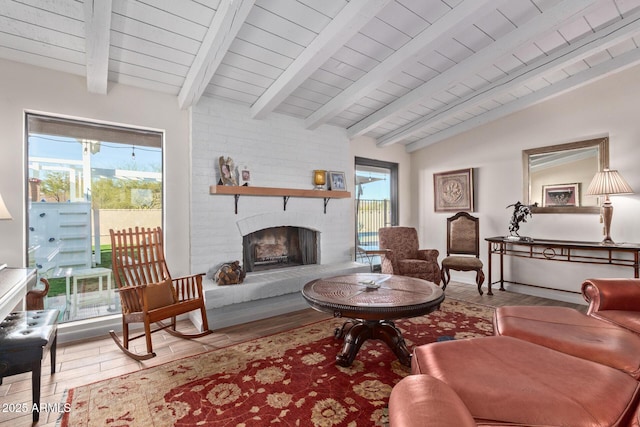 living room featuring wood ceiling, a brick fireplace, vaulted ceiling with beams, and light wood finished floors