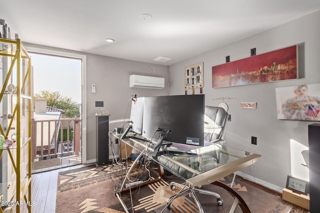 office space featuring a wall mounted AC, wood finished floors, and baseboards