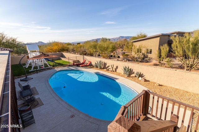 view of pool featuring a fenced backyard, a mountain view, a fenced in pool, and a patio