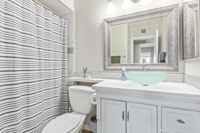 bathroom featuring vanity, backsplash, curtained shower, and toilet