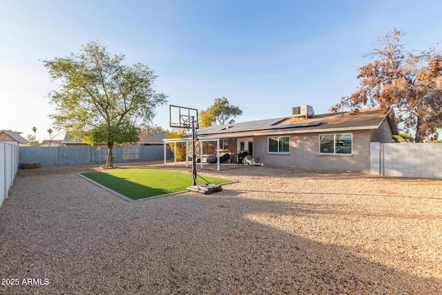 back of property with central air condition unit, a patio area, and solar panels