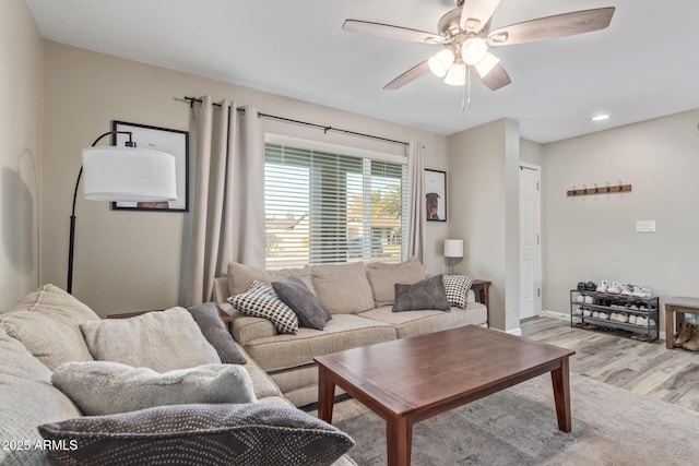 living room with light hardwood / wood-style flooring and ceiling fan