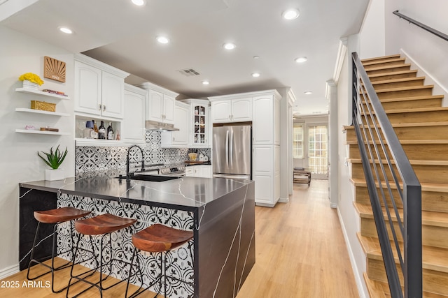 4419 N 24th Way, Phoenix, AZ 85016 - kitchen with freestanding refrigerator, a peninsula, a kitchen breakfast bar, dark countertops, and white cabinetry