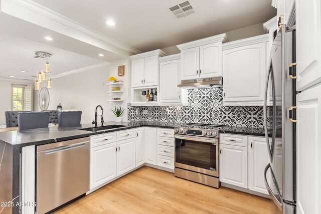 4419 N 24th Way, Phoenix, AZ 85016 - kitchen featuring appliances with stainless steel finishes, a sink, under cabinet range hood, dark countertops, and a peninsula