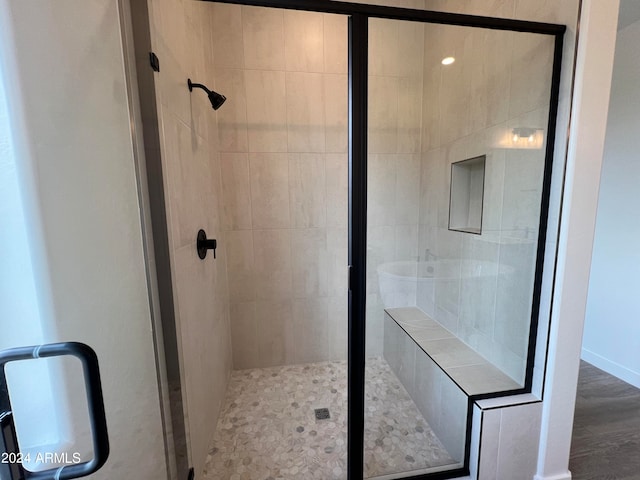 bathroom featuring a shower with door and wood-type flooring