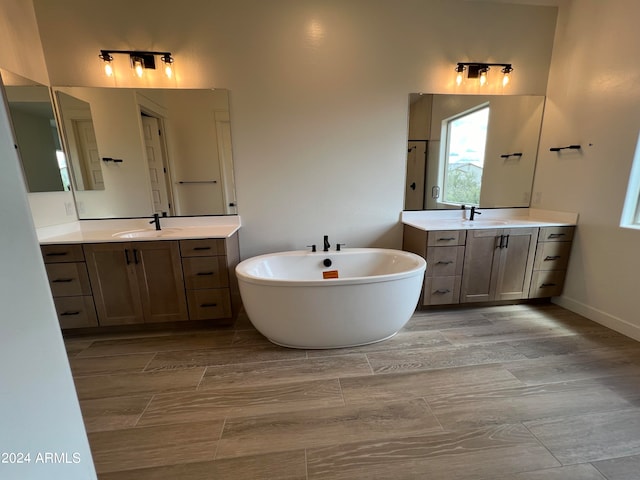 bathroom featuring a bath, tile floors, oversized vanity, and dual sinks