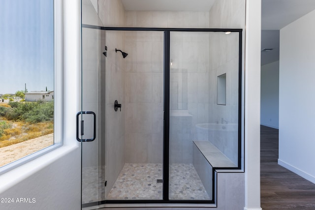 bathroom with an enclosed shower and hardwood / wood-style floors