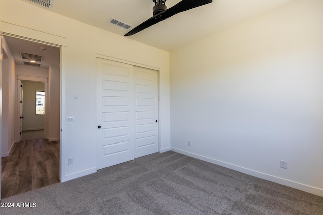 unfurnished bedroom featuring dark hardwood / wood-style floors, a closet, and ceiling fan