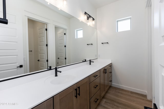 bathroom with dual bowl vanity and wood-type flooring