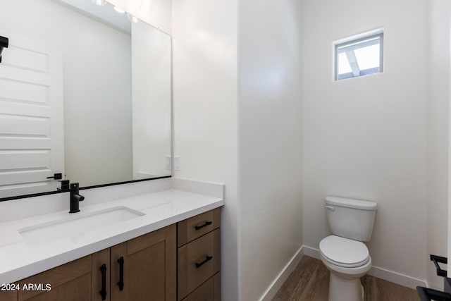 bathroom with vanity, toilet, and hardwood / wood-style floors