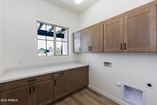 laundry room featuring washer hookup, hookup for an electric dryer, cabinets, hardwood / wood-style flooring, and hookup for a gas dryer