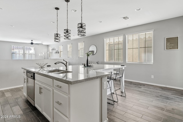 kitchen with a center island with sink, sink, dishwasher, white cabinets, and hardwood / wood-style flooring