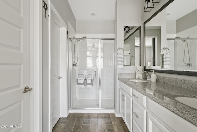 bathroom with vanity, hardwood / wood-style floors, and a shower with door