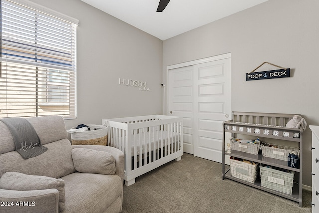 bedroom featuring ceiling fan, a nursery area, a closet, and carpet