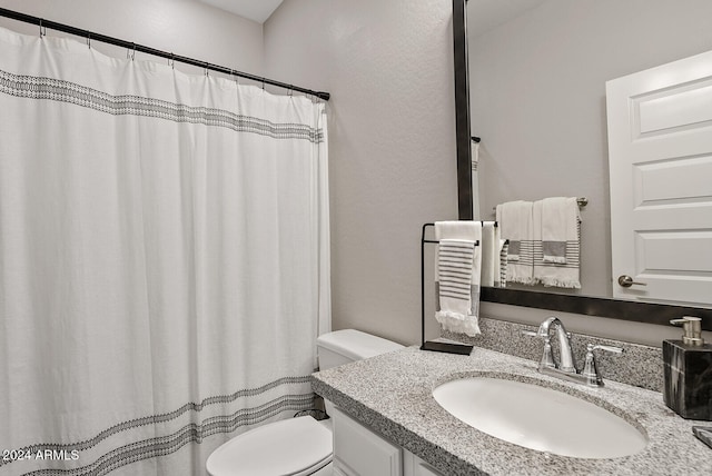 bathroom with walk in shower, vanity, and toilet