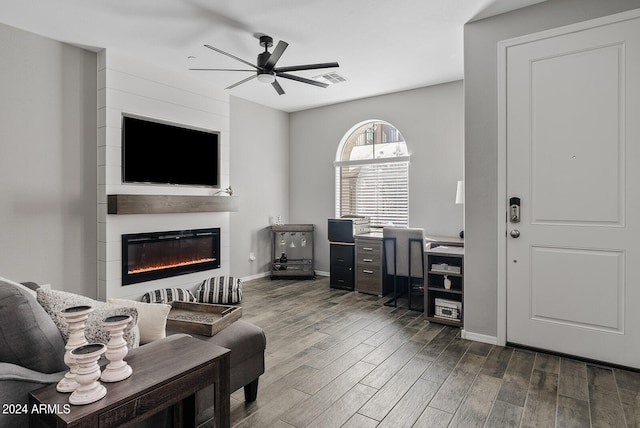 living room featuring a large fireplace, hardwood / wood-style flooring, and ceiling fan