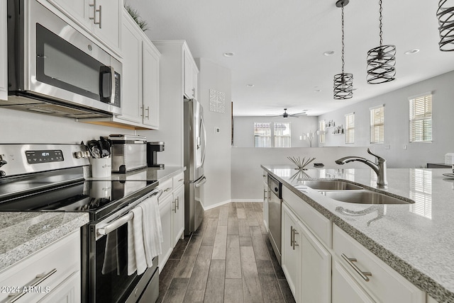 kitchen featuring dark hardwood / wood-style floors, sink, stainless steel appliances, hanging light fixtures, and white cabinets