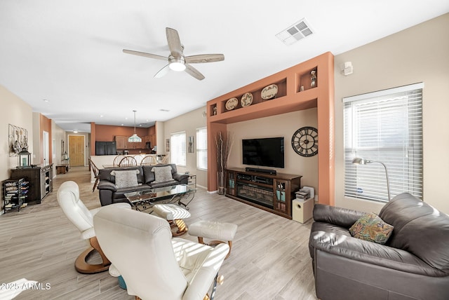 living room featuring ceiling fan and light wood-type flooring