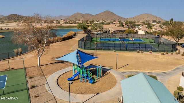 view of community featuring a playground, tennis court, and a mountain view