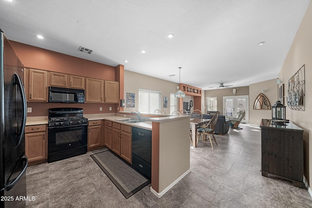 kitchen with french doors, sink, hanging light fixtures, kitchen peninsula, and black appliances