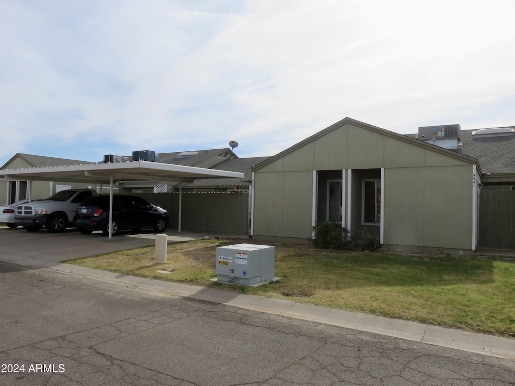 view of front of house featuring central AC unit, a carport, and a front yard