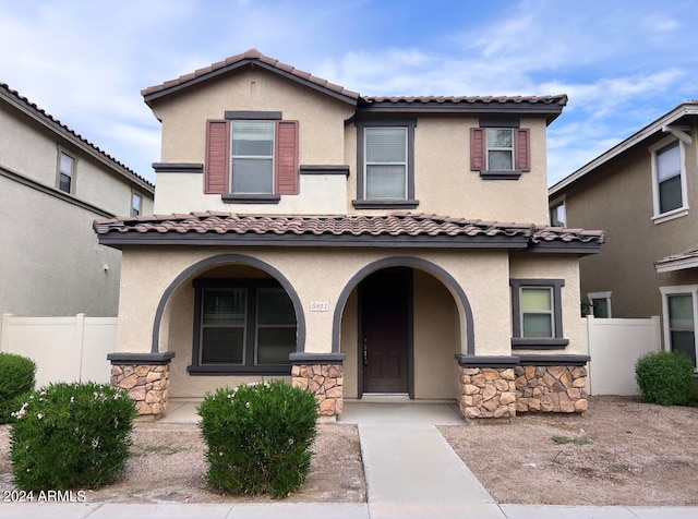 mediterranean / spanish home featuring covered porch