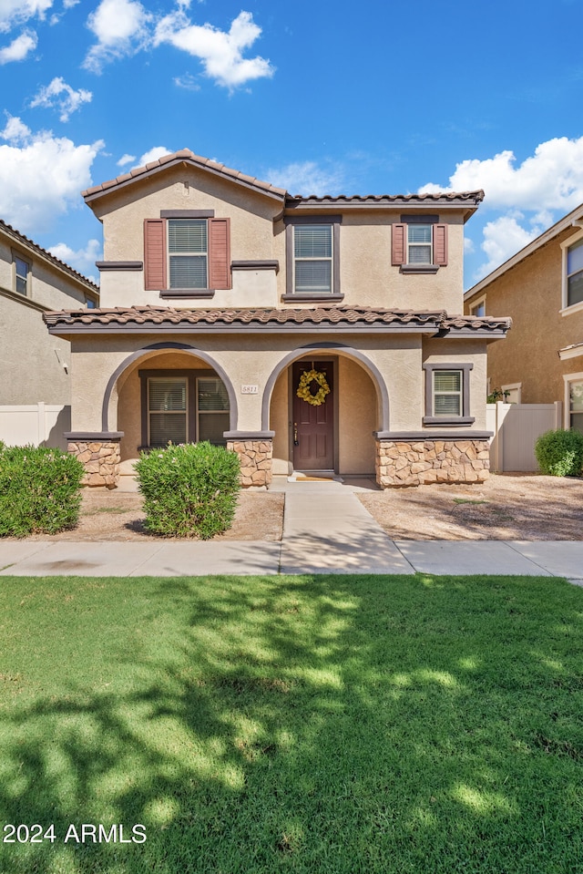 mediterranean / spanish home featuring a front lawn