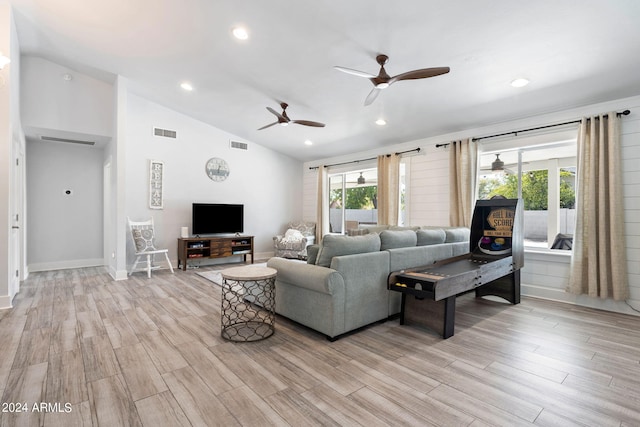 living room with lofted ceiling, ceiling fan, and light hardwood / wood-style floors