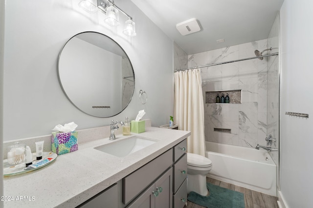 full bathroom with shower / bath combo with shower curtain, hardwood / wood-style flooring, vanity, and toilet