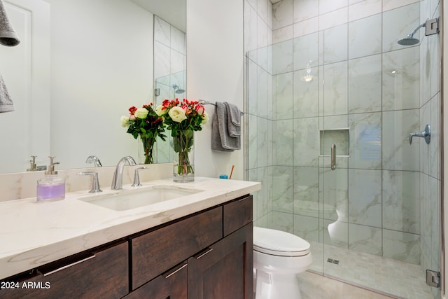 bathroom with a shower with shower door, tile patterned flooring, toilet, and vanity