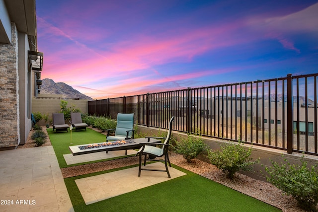 yard at dusk featuring a patio, a mountain view, and an outdoor fire pit