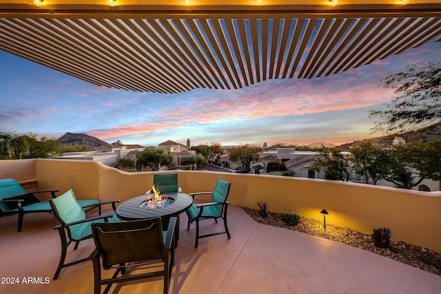 patio terrace at dusk featuring a fire pit