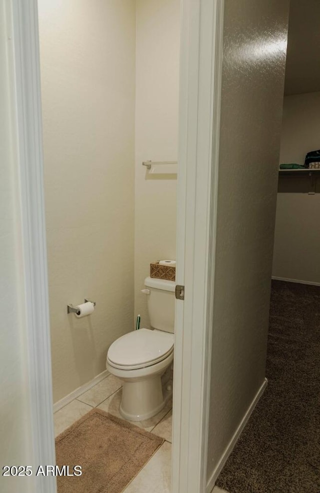 bathroom featuring tile patterned floors, toilet, and baseboards