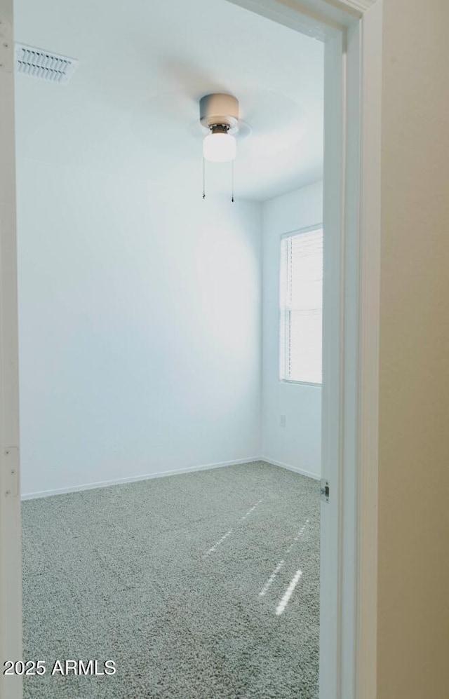 empty room featuring visible vents, baseboards, and a ceiling fan