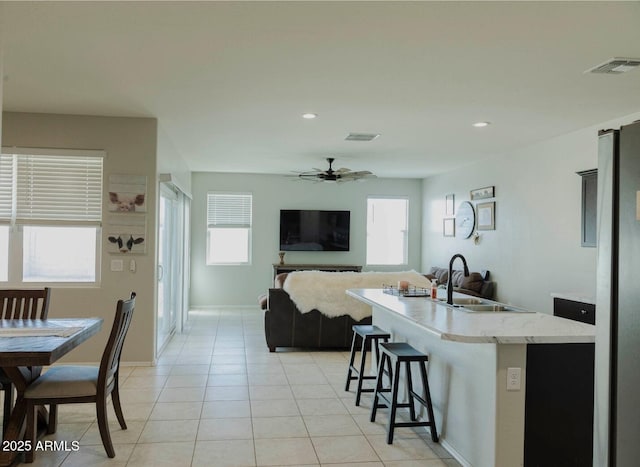 kitchen featuring visible vents, plenty of natural light, a ceiling fan, and a sink