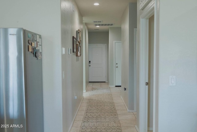 hallway featuring light tile patterned floors, visible vents, baseboards, and recessed lighting