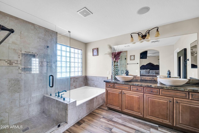 11965 W Monte Vista Rd, Avondale, AZ 85392 - bathroom featuring a bath, double vanity, a shower stall, ensuite bathroom, and wood finished floors
