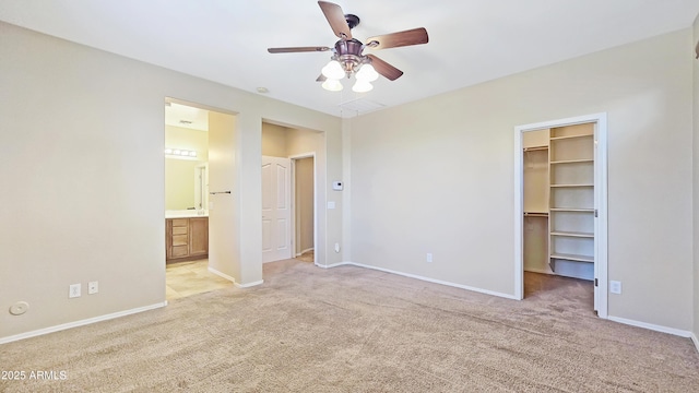 23853 W Hammond Ln, Buckeye, AZ 85326 - unfurnished bedroom with a walk in closet, light carpet, a closet, ensuite bath, and a ceiling fan