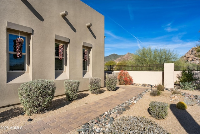 view of patio / terrace featuring fence and a mountain view