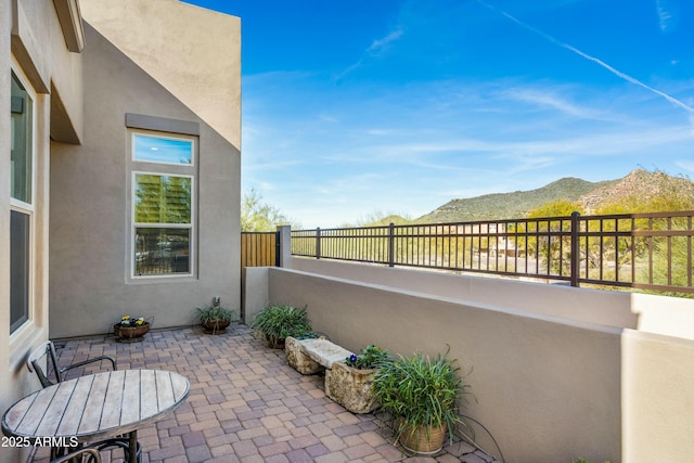 view of patio with fence and a mountain view