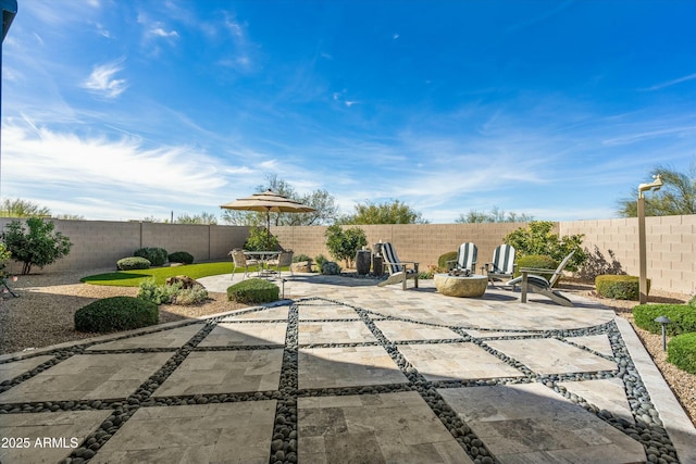 view of patio featuring a fenced backyard and an outdoor fire pit