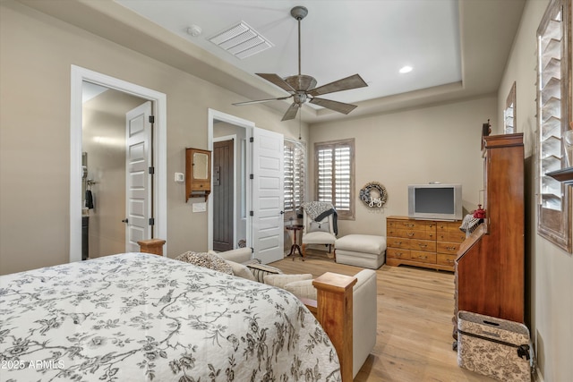 bedroom featuring a tray ceiling, recessed lighting, visible vents, light wood-style flooring, and ceiling fan