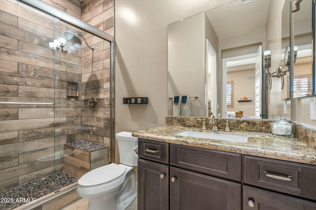 full bath featuring toilet, vanity, a stall shower, and visible vents