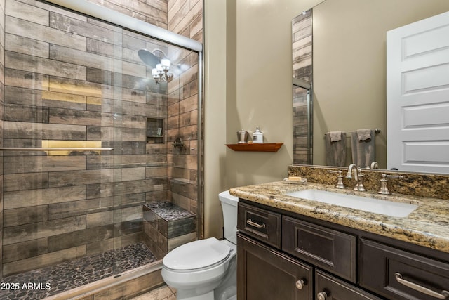 full bath with a stall shower, toilet, and vanity