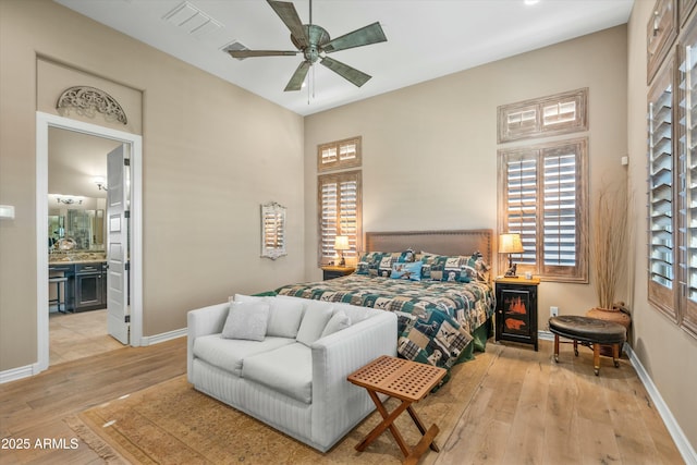 bedroom with baseboards, ensuite bathroom, and light wood-type flooring