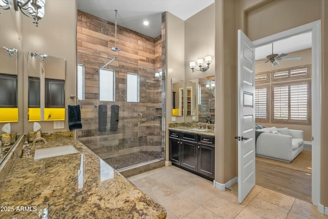 full bathroom featuring a shower stall, a ceiling fan, two vanities, a sink, and tile patterned flooring