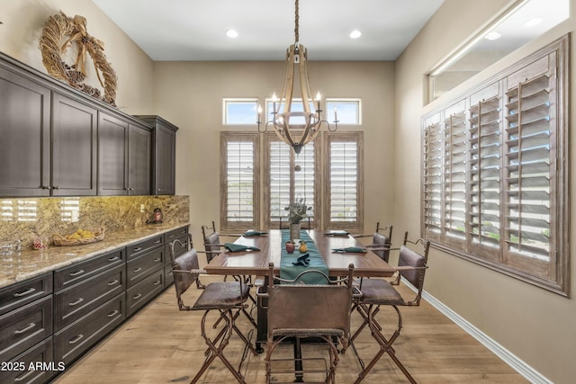 dining space with baseboards, light wood-style flooring, recessed lighting, and a chandelier