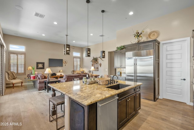 kitchen with visible vents, light wood-style flooring, a sink, and stainless steel appliances