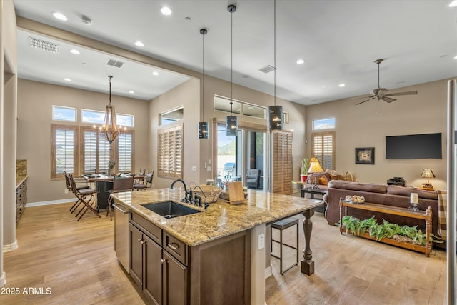 kitchen featuring dishwasher, light wood-style flooring, a sink, and visible vents